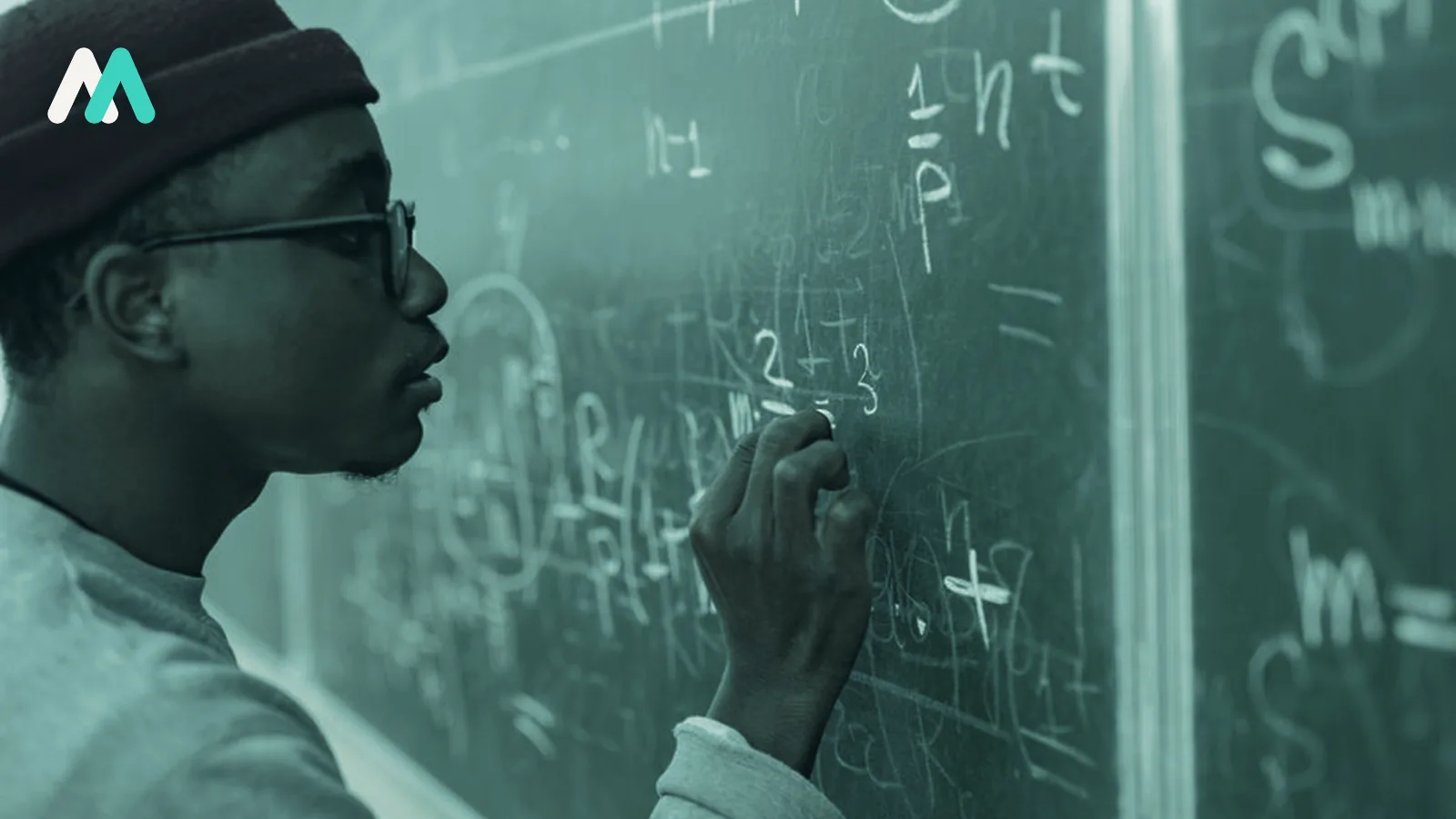 A person working through equations on a blackboard.