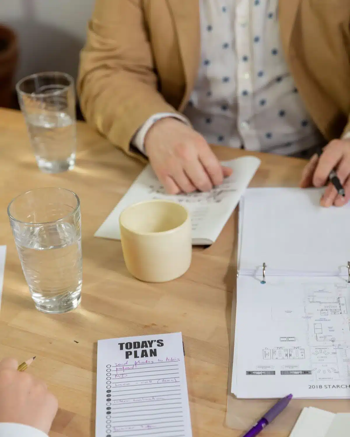 Two people working through a written plan at a table