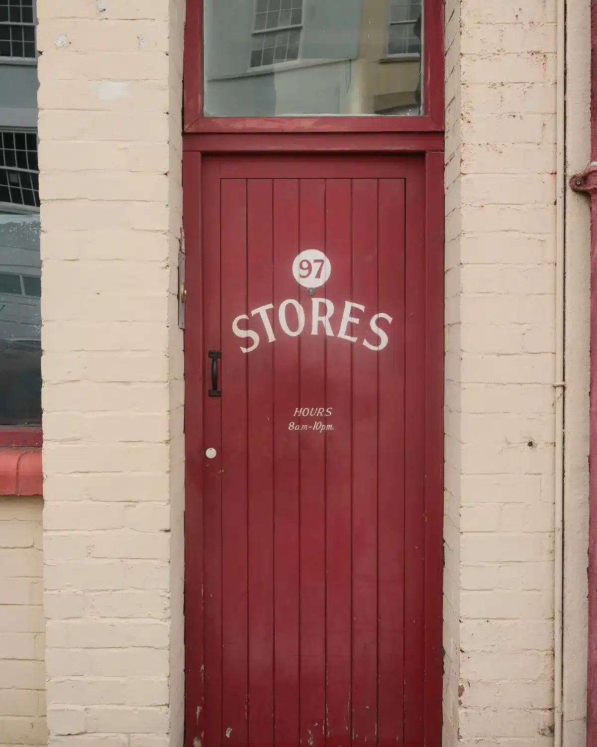 A red wooden door marked 97 Stores on a Bristol street