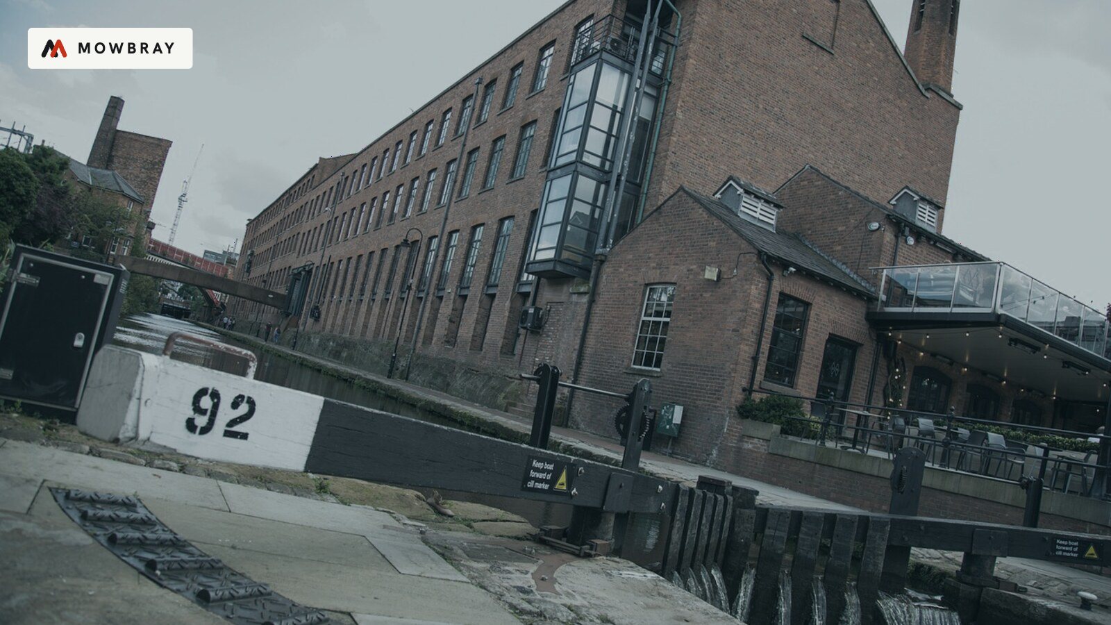 A converted red-brick mill building beside a canal