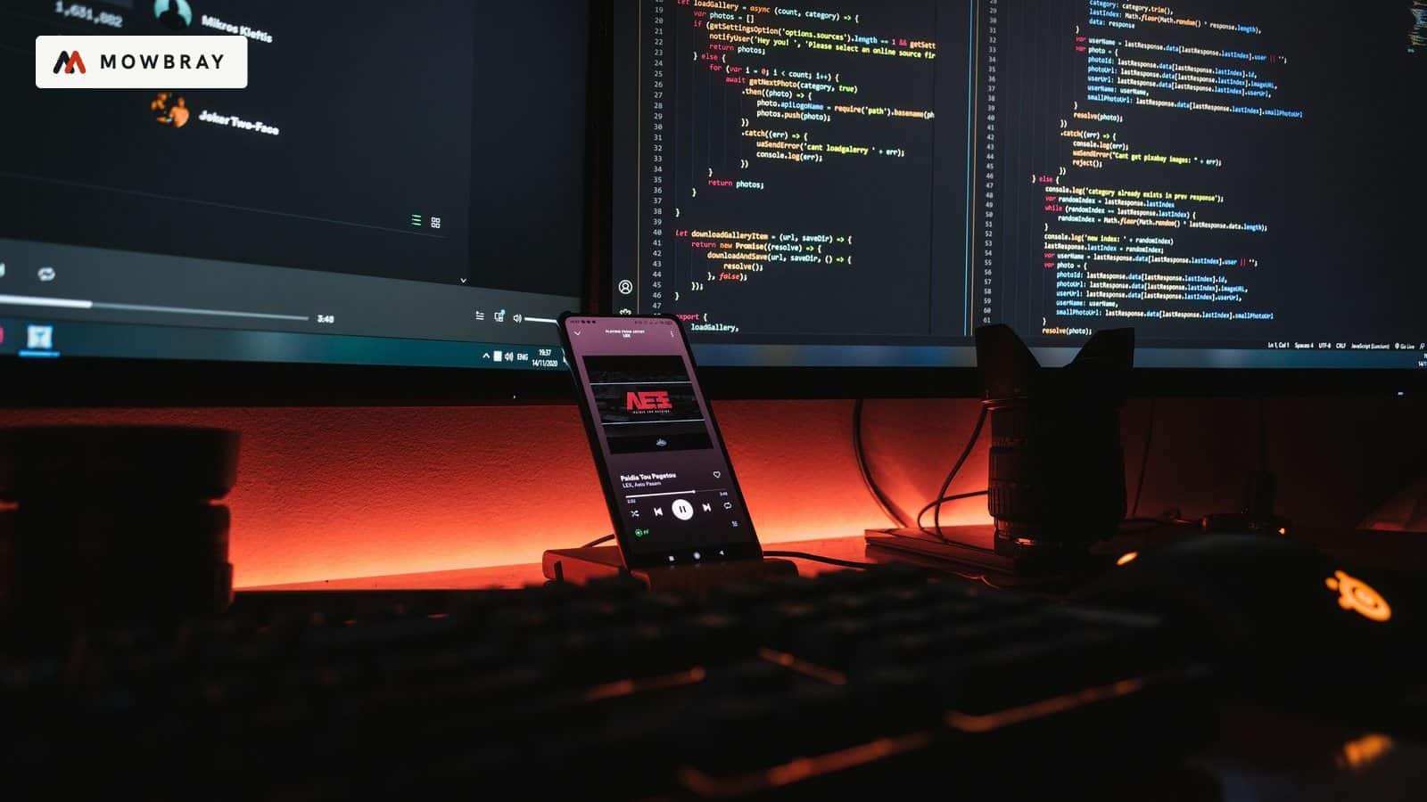 Lines of code on monitors glowing in a dark room