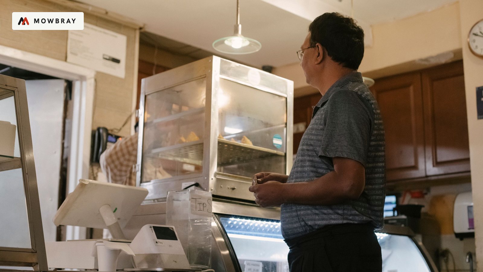 A customer waiting at the counter of a small shop