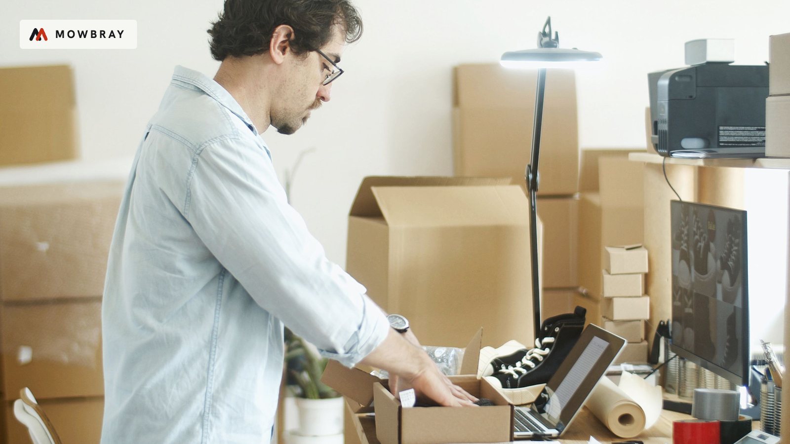 A man packing orders into boxes in a small office