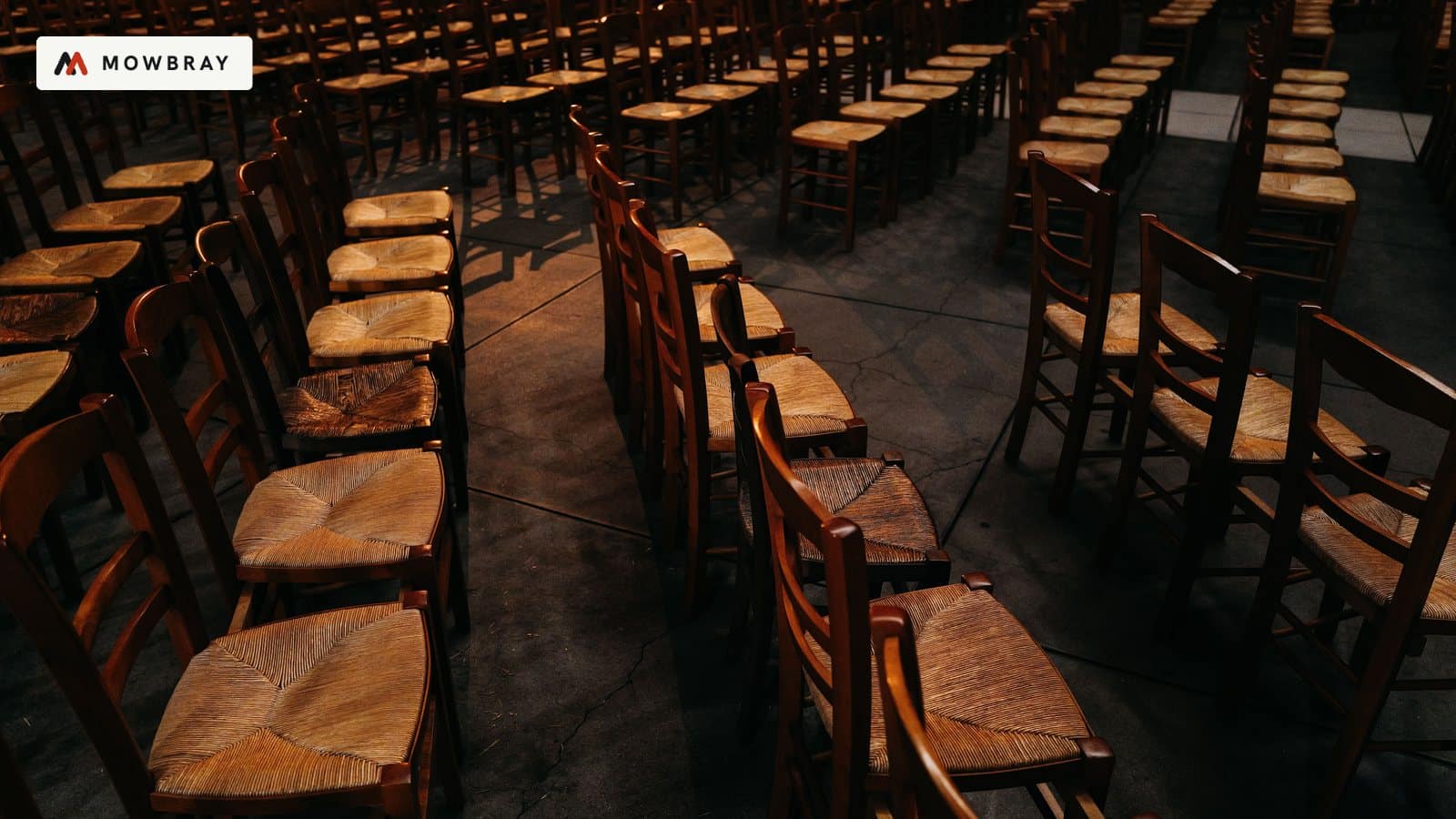 Rows of empty wooden chairs in a hall